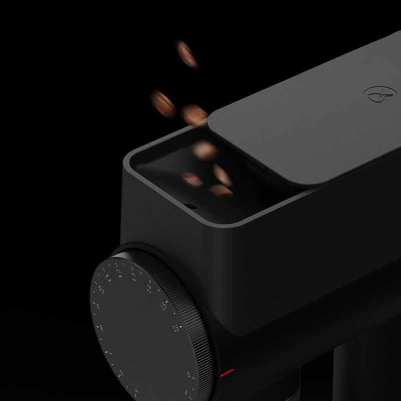 Close-up of TIMEMORE Sculptor 064s grinder with coffee beans dropping into the hopper.