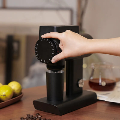 A hand adjusts the grind size on the TIMEMORE Sculptor 064s grinder, designed for espresso enthusiasts.